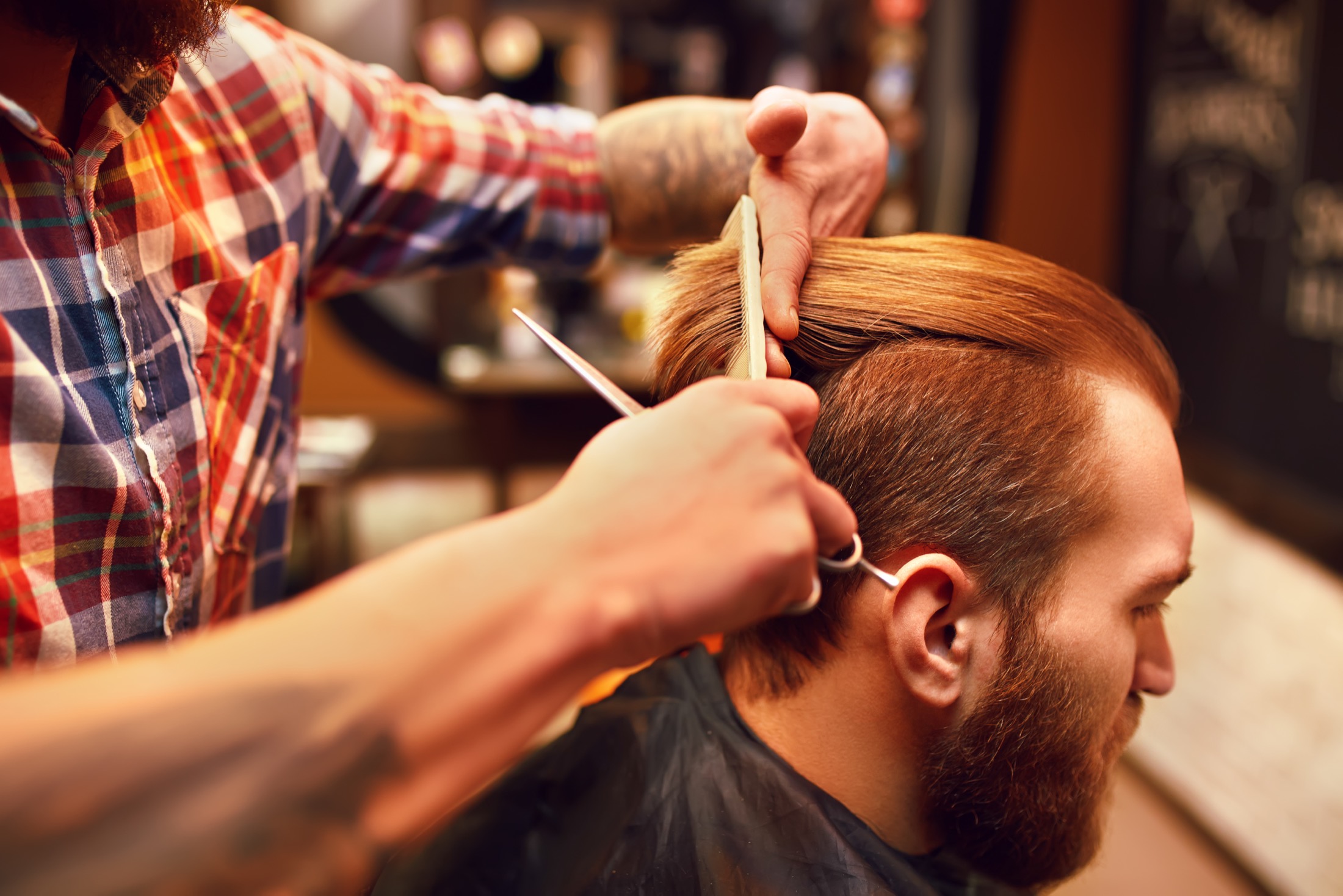 Barber completing a precise scissor haircut.