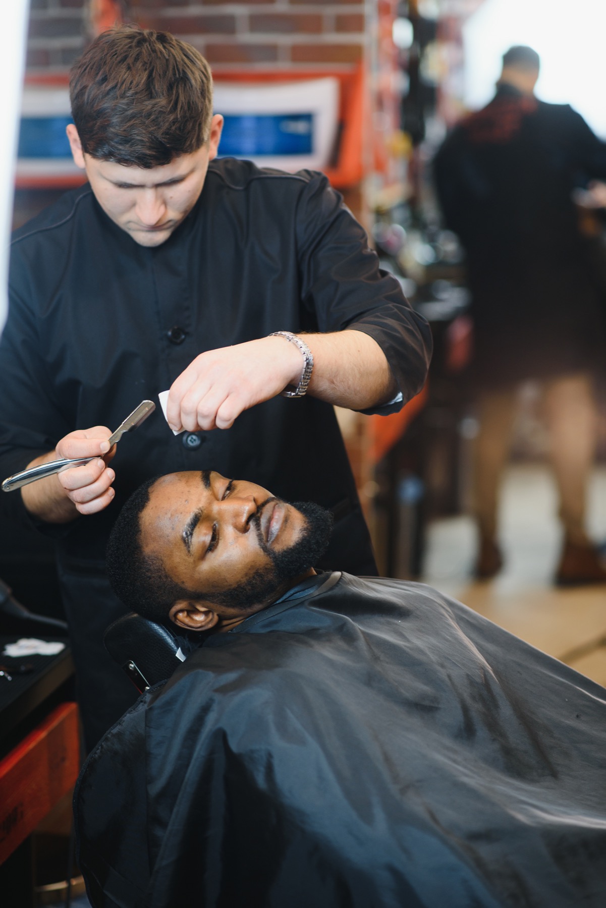 Straight razor shaping a beard during a hot-towel shave.