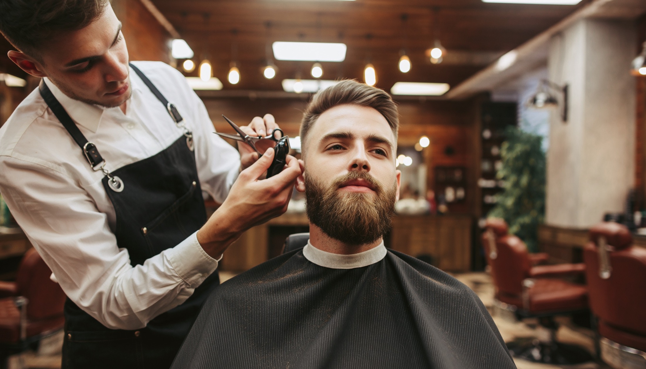 Modern barber shaping a sharp fade under studio lighting.