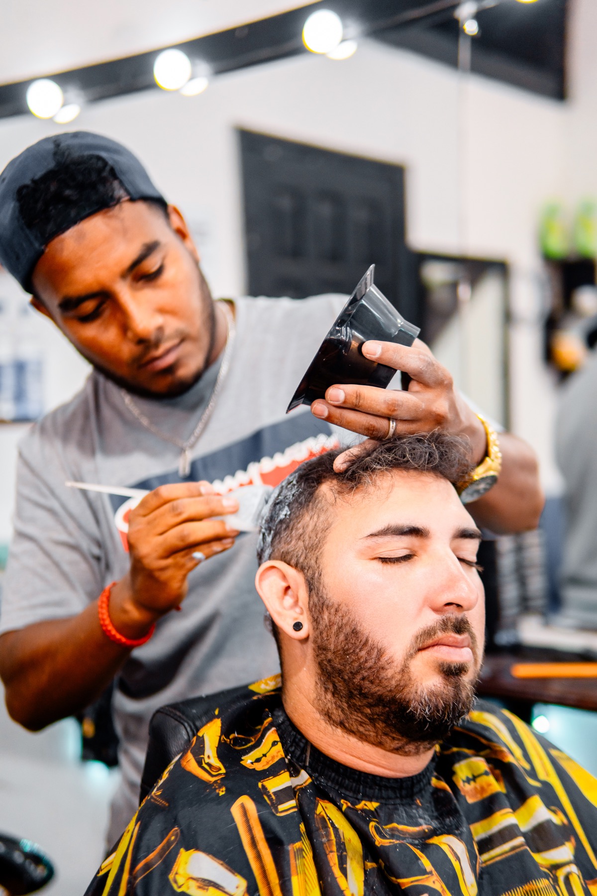 Barber applying creative color product with a precision brush.
